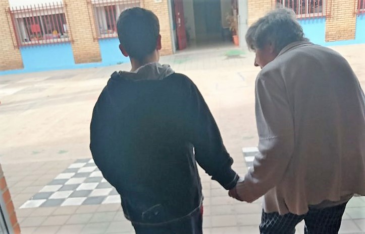 Adolescente lleva de la mano a una persona mayor